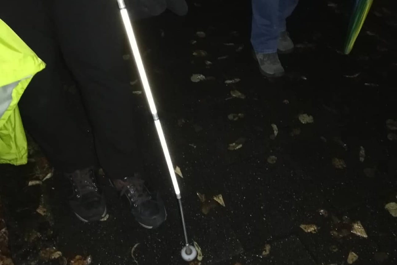 Ein Blindenstock auf dem Bürgersteig